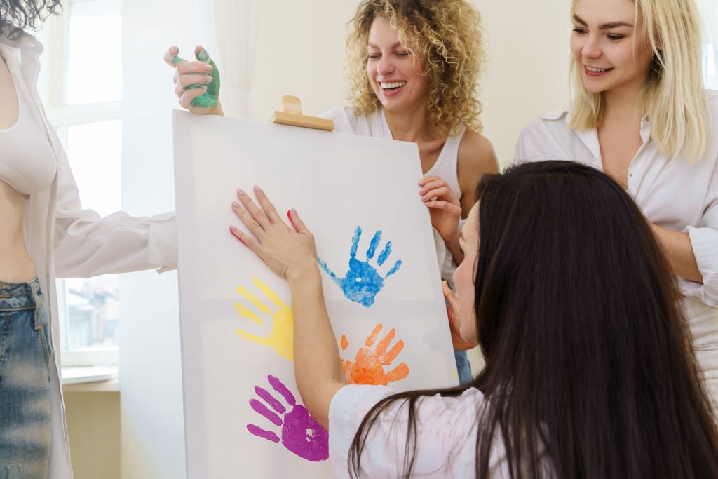 Mothers having fun on canvas painting during parent training.