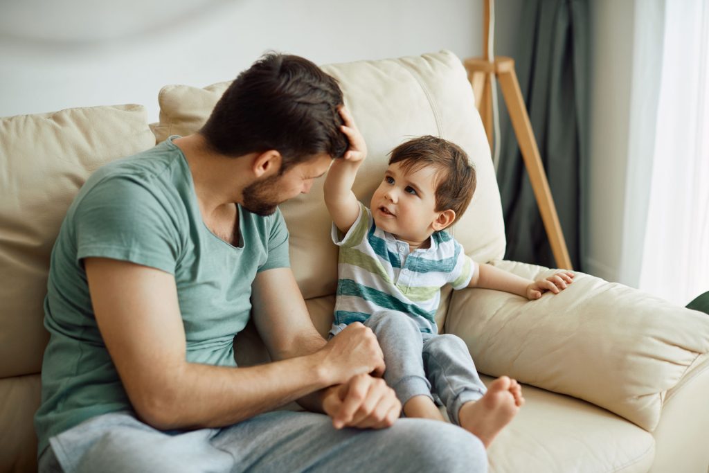 Father and son sitting on a couch.