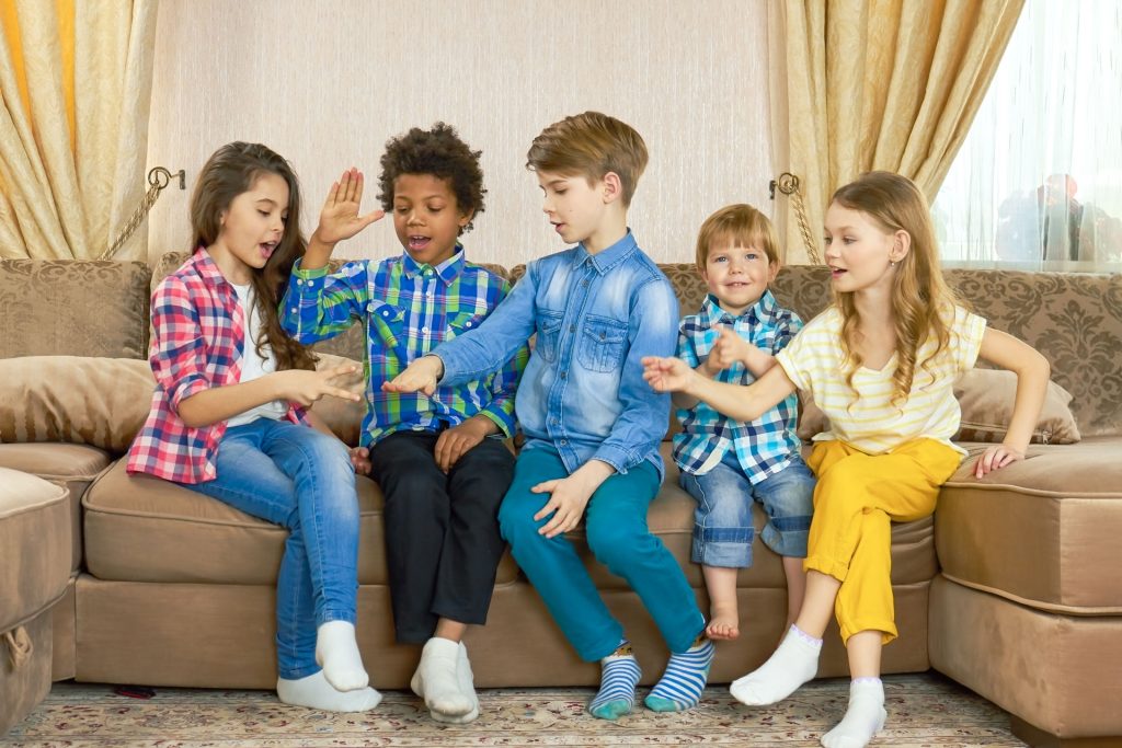 Kids playing rock, paper, scissors, showing the effect of ABA Therapy on social skills development.