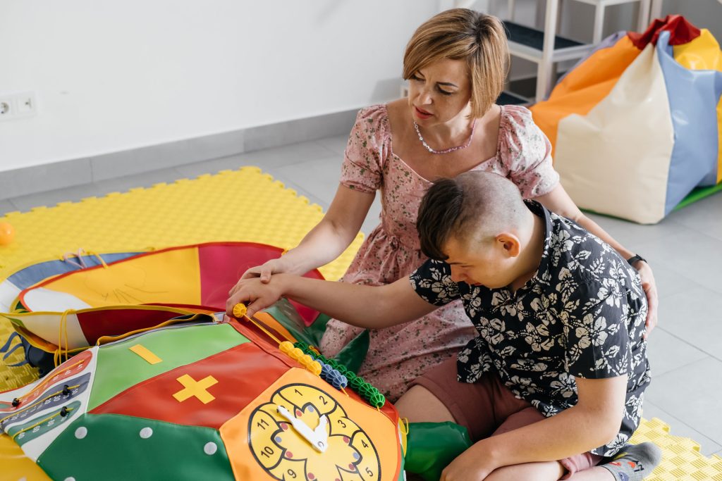 Person with disability doing sensory activity with toys.