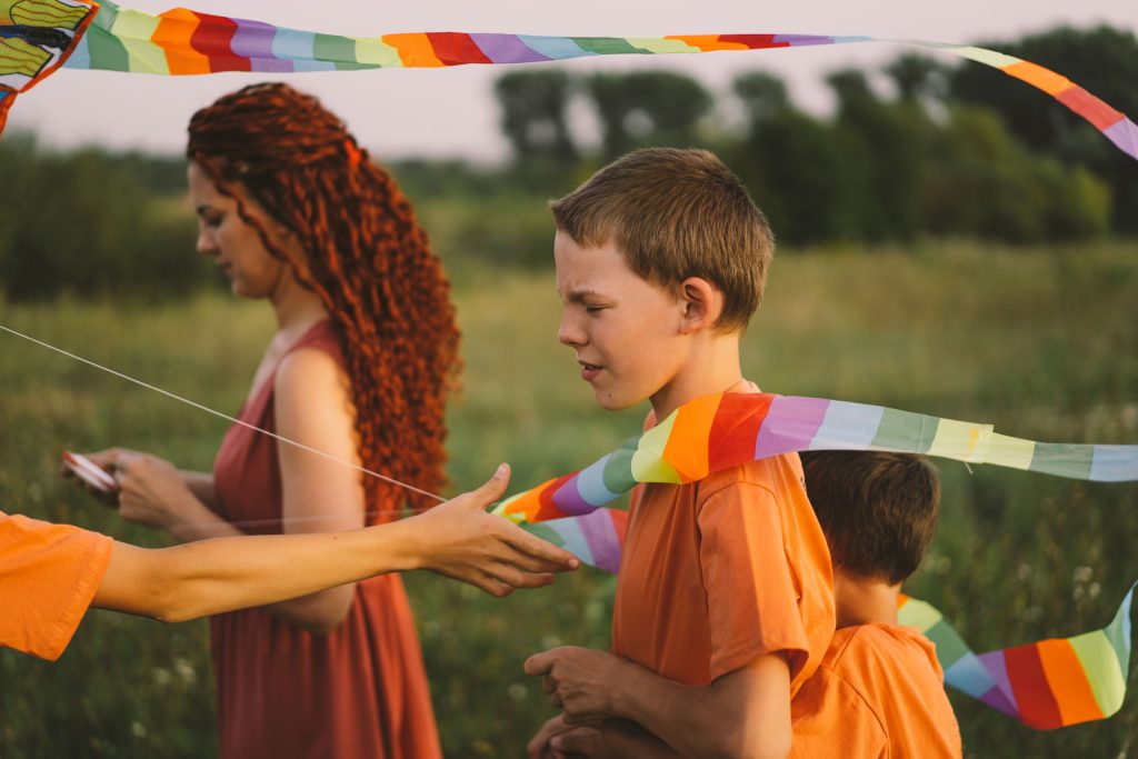 Family with cultural sensitivity flying a kite in a field.