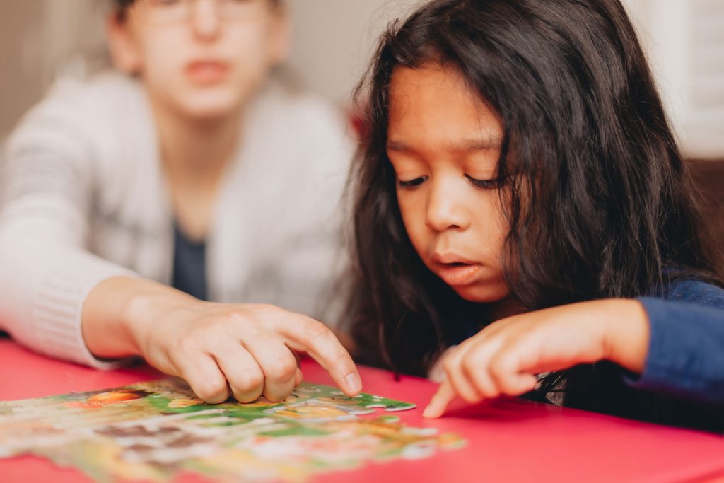 Mother teaching a child to do the puzzle.