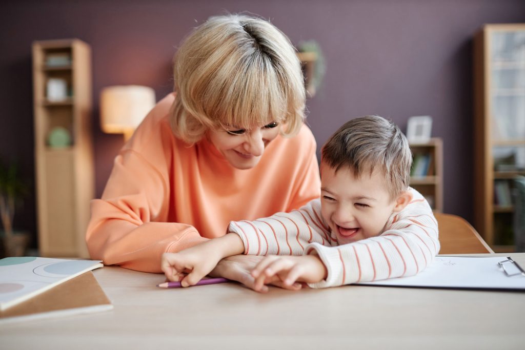Mother playing with a boy that has down syndrome.