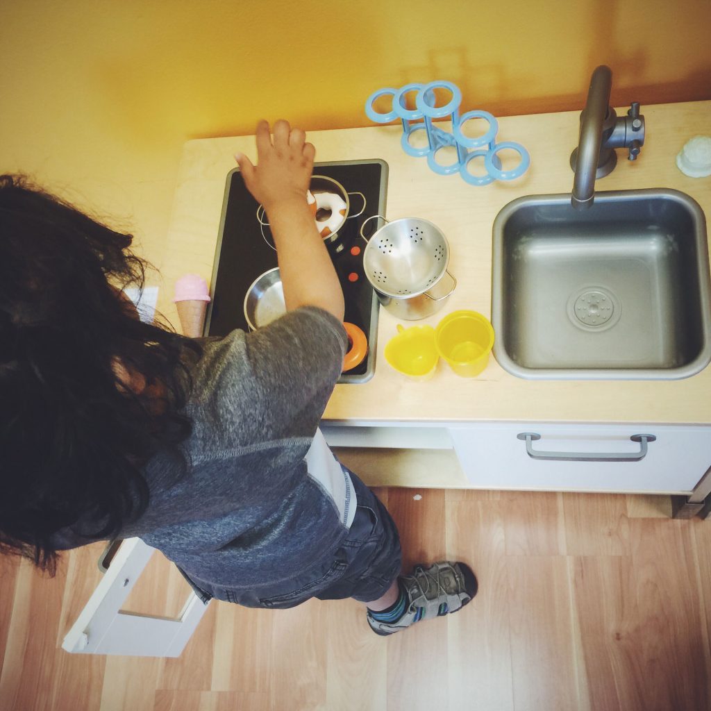 Little kid playing in the kitchen.