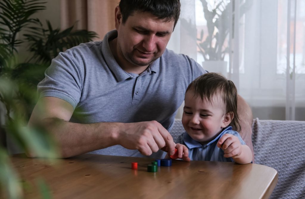 Dad and 1 year old son playing.
