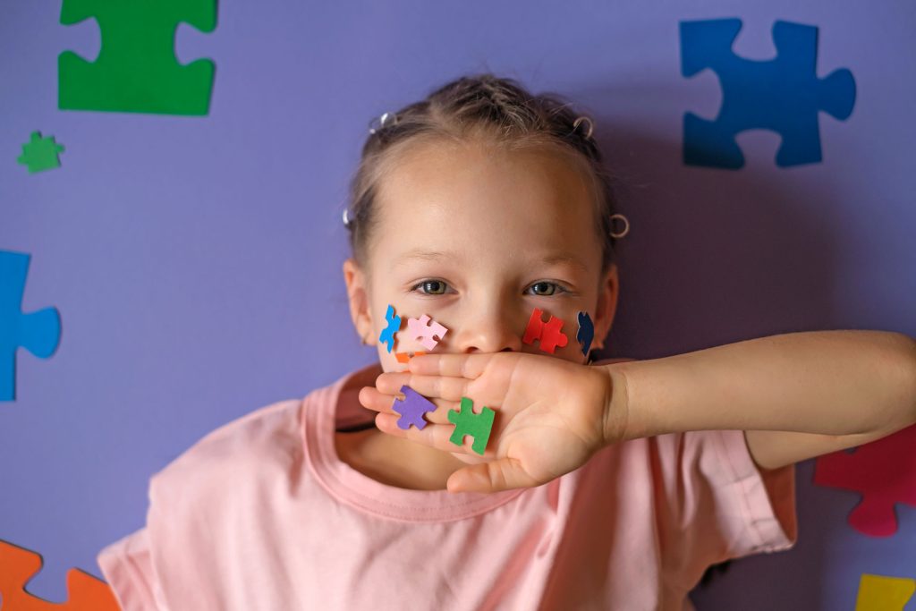 Child with autism in multi-colored puzzle pieces.