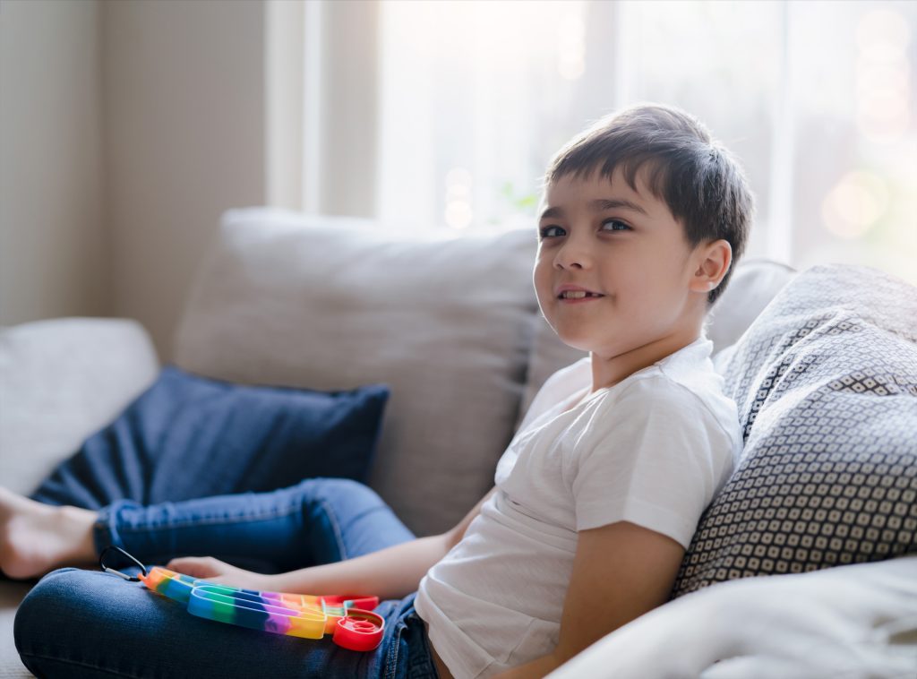 Happy Kid sitting on sofa.