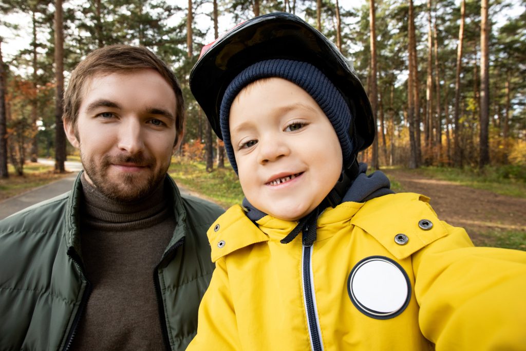 Little boy and his father in park.